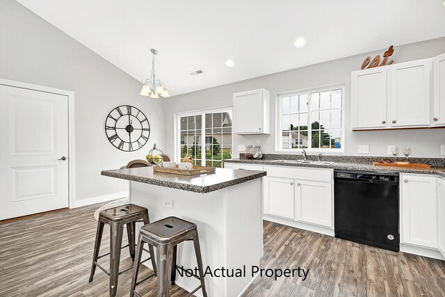 kitchen featuring white cabinets, dishwasher, a center island, lofted ceiling, and a breakfast bar area