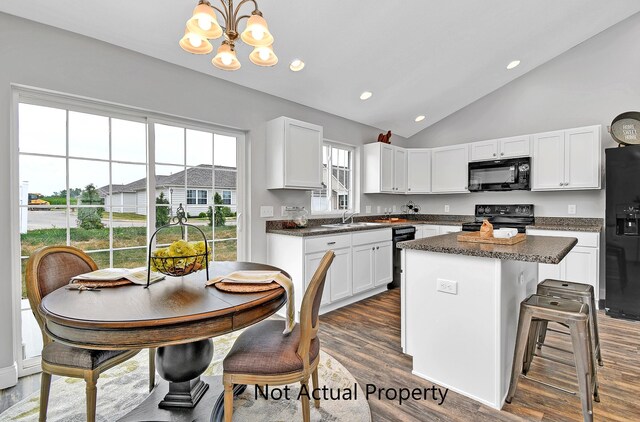 kitchen with decorative light fixtures, a notable chandelier, a kitchen island, black appliances, and white cabinets