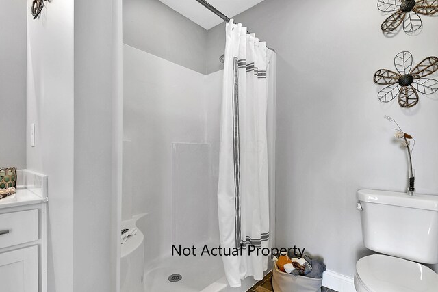 bathroom featuring toilet, vanity, and a shower with shower curtain