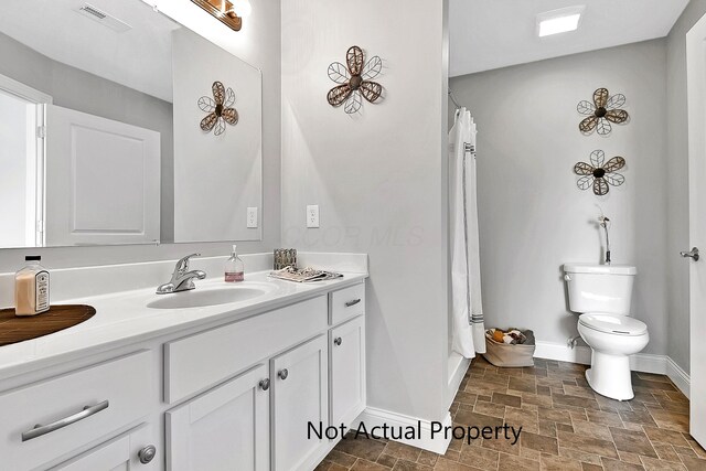 bathroom featuring toilet, a shower with curtain, and vanity