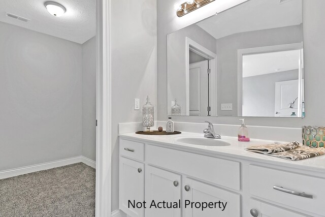 bathroom with a textured ceiling and vanity