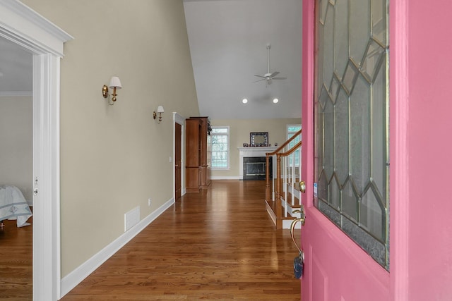 entrance foyer with ceiling fan, dark hardwood / wood-style flooring, crown molding, and vaulted ceiling