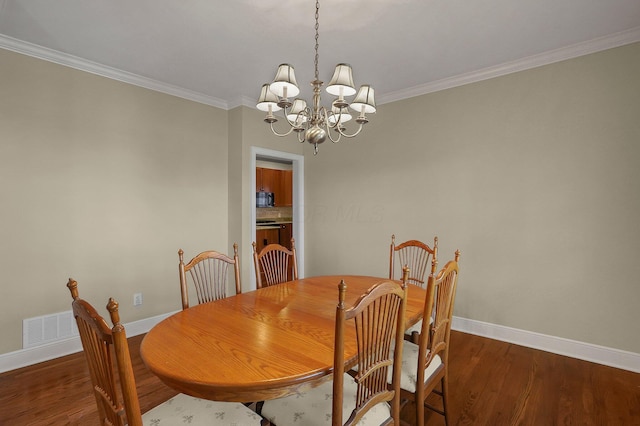 dining room featuring ornamental molding, dark hardwood / wood-style floors, and a notable chandelier