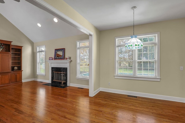 unfurnished living room with wood-type flooring, vaulted ceiling, and a premium fireplace