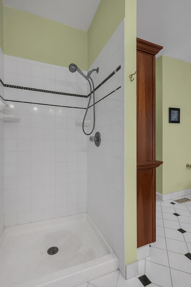 bathroom featuring tile patterned flooring and tiled shower