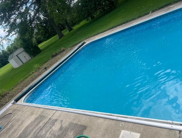 view of pool with a lawn