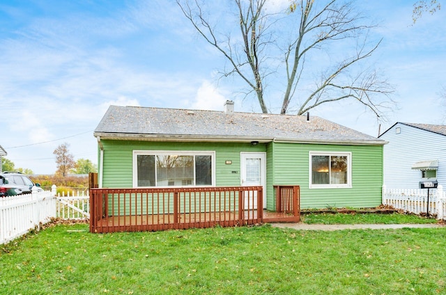 rear view of house with a lawn and a wooden deck