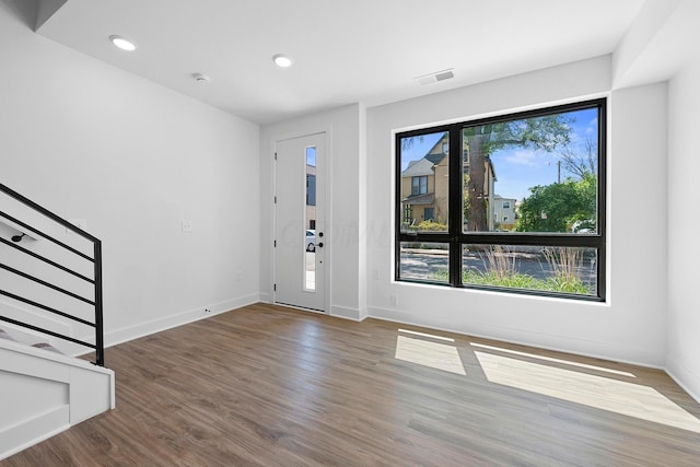 entryway with a healthy amount of sunlight and dark hardwood / wood-style flooring