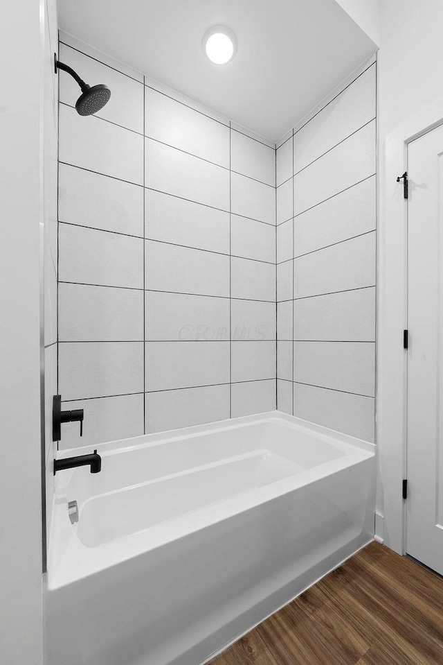 bathroom featuring wood-type flooring and tub / shower combination