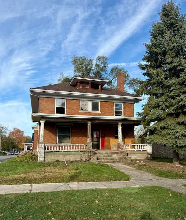 view of front of property featuring covered porch and a front yard