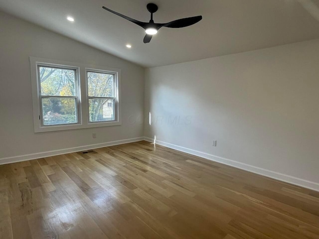 spare room with ceiling fan, lofted ceiling, and light hardwood / wood-style flooring