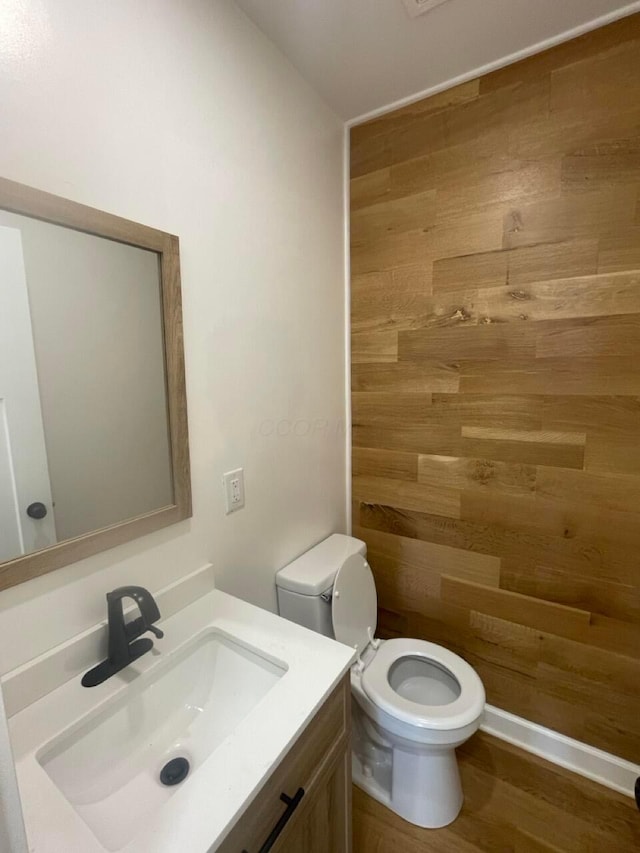 bathroom featuring vanity, hardwood / wood-style flooring, and toilet