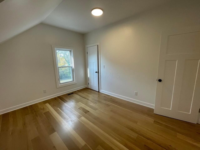 additional living space featuring light hardwood / wood-style floors and lofted ceiling