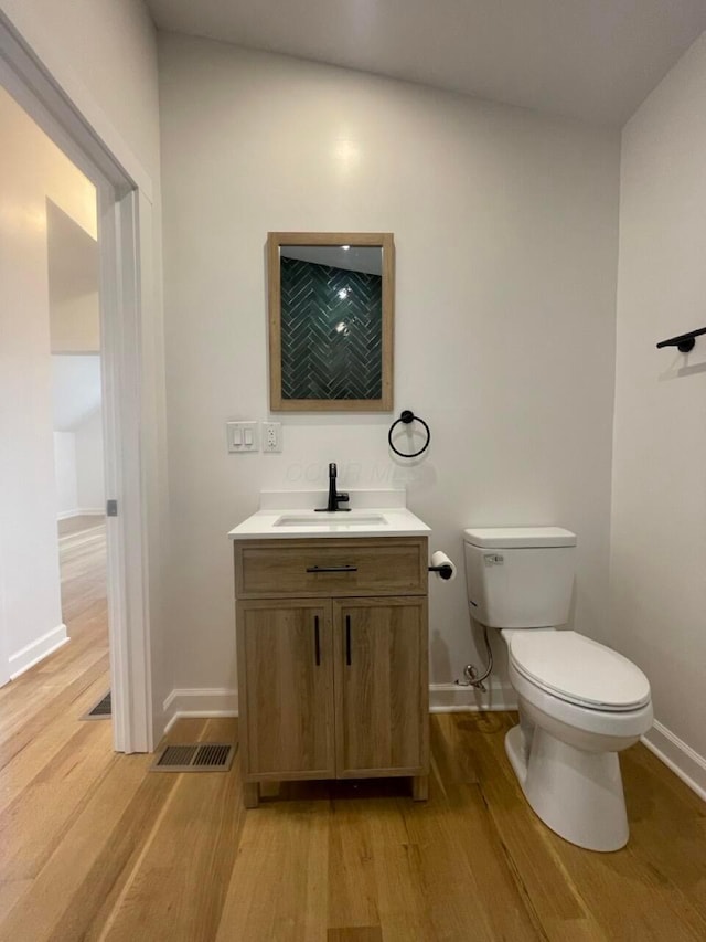 bathroom with vanity, hardwood / wood-style flooring, and toilet