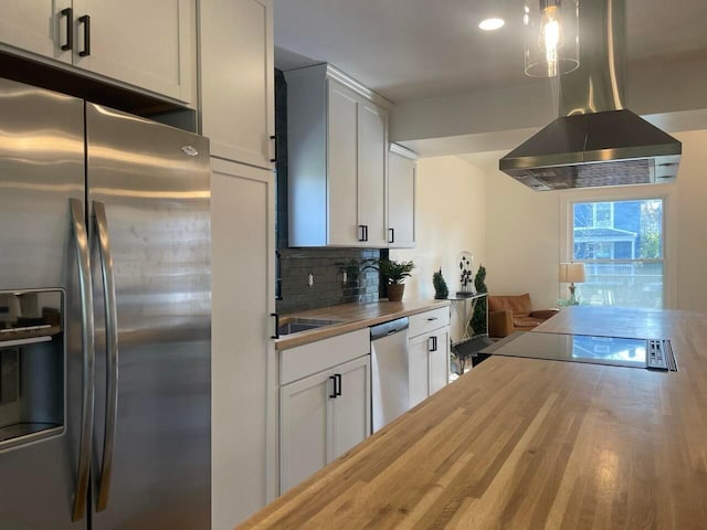 kitchen featuring white cabinetry, butcher block counters, island range hood, and appliances with stainless steel finishes