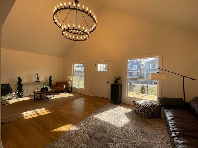 living room featuring a notable chandelier, wood-type flooring, and high vaulted ceiling