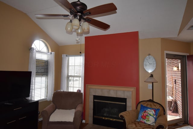 sitting room featuring lofted ceiling, ceiling fan, and a tile fireplace