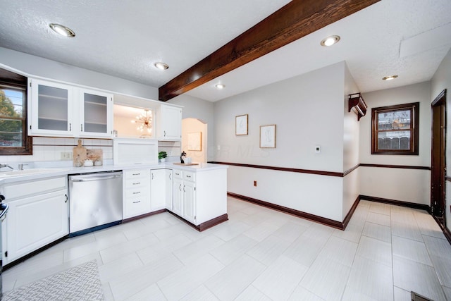 kitchen featuring stainless steel dishwasher, decorative backsplash, white cabinets, and beamed ceiling