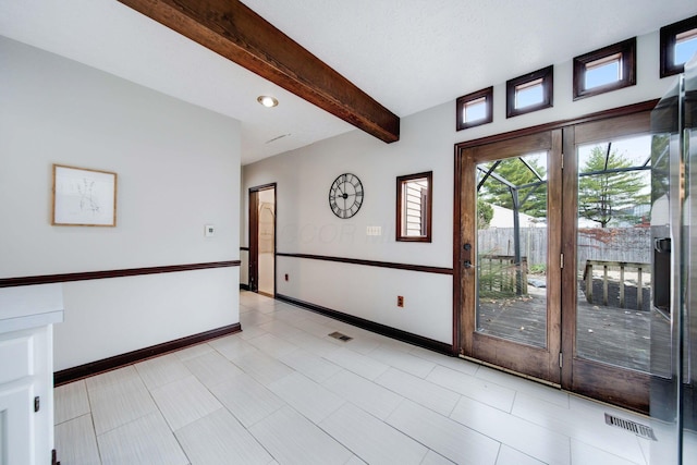 tiled spare room featuring beam ceiling