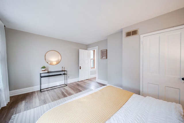 bedroom with wood-type flooring and a closet