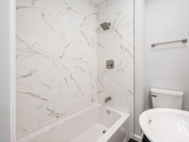 bathroom with toilet and tiled shower / bath