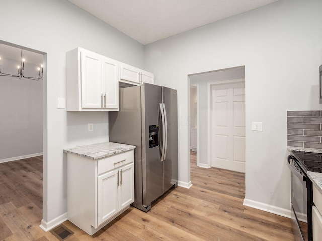 kitchen featuring stainless steel refrigerator with ice dispenser, light wood-type flooring, electric range, decorative light fixtures, and white cabinetry