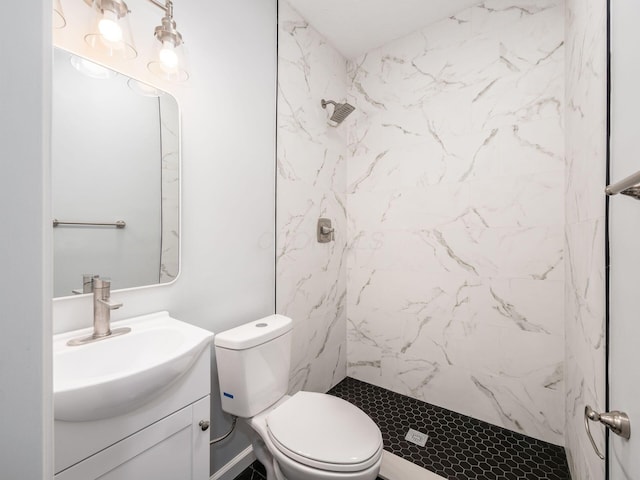 bathroom featuring tiled shower, vanity, and toilet