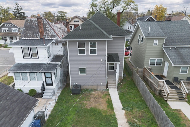 back of house with central AC and a yard