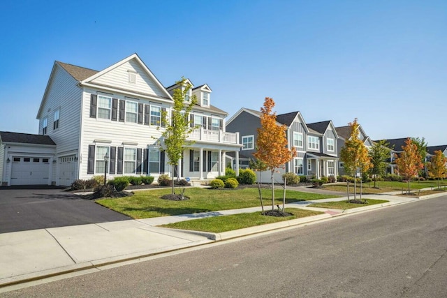 view of front facade with a front yard, driveway, a garage, and a residential view