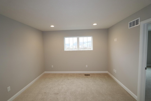 spare room with light carpet, visible vents, recessed lighting, and baseboards