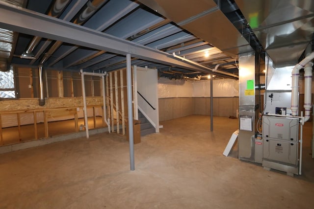 unfinished basement with stairs and heating unit