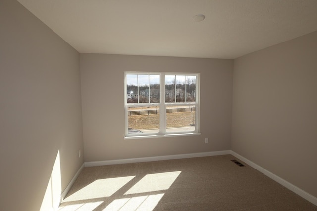 spare room with visible vents, carpet flooring, and baseboards