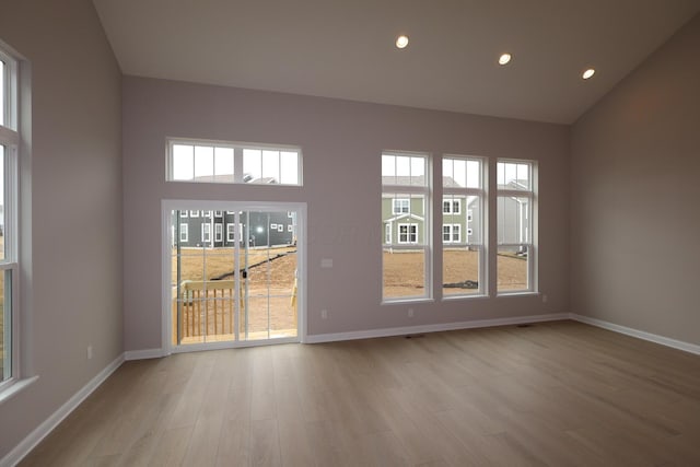 spare room with light wood-style flooring, recessed lighting, and baseboards