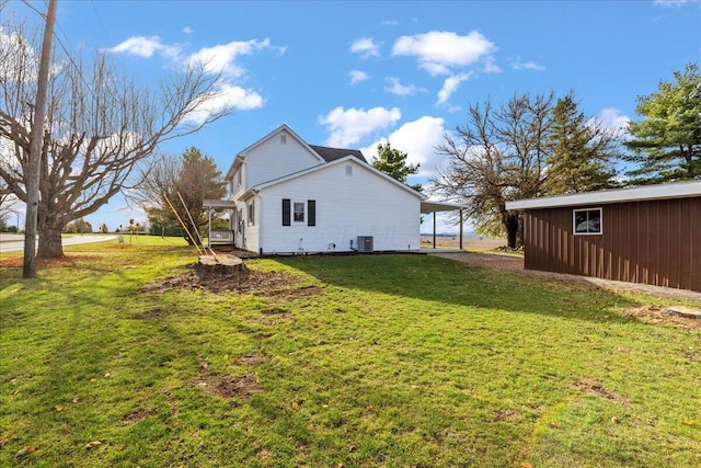 view of yard with central AC unit and a carport