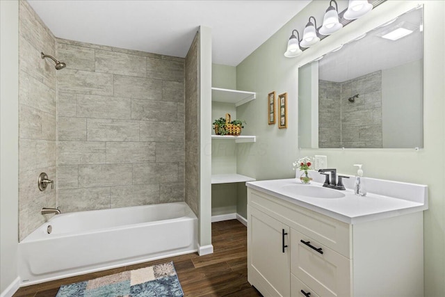 bathroom with tiled shower / bath combo, wood-type flooring, and vanity