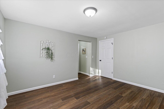 unfurnished room with dark hardwood / wood-style flooring