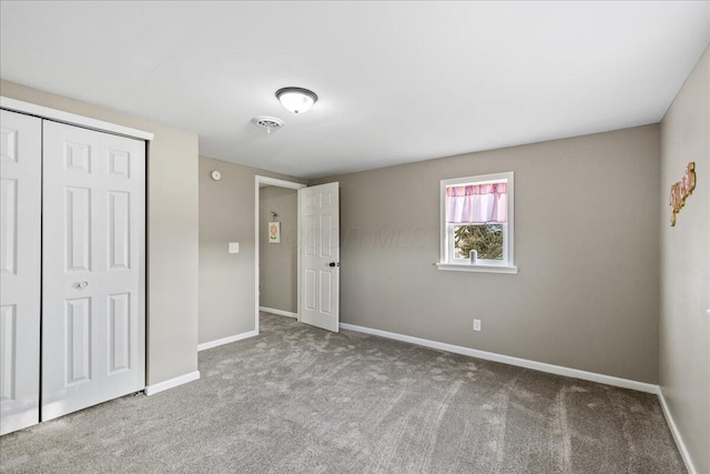 unfurnished bedroom featuring light colored carpet and a closet