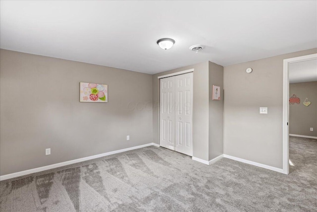 unfurnished bedroom featuring carpet flooring and a closet