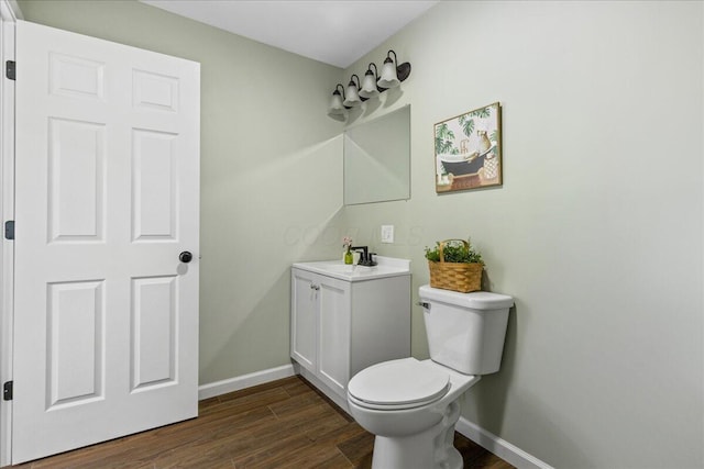 bathroom with toilet, vanity, and hardwood / wood-style flooring