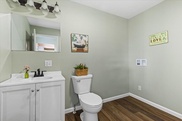 bathroom with hardwood / wood-style floors, vanity, and toilet