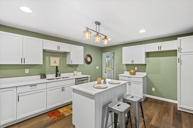 kitchen with white cabinets, dark hardwood / wood-style floors, sink, and hanging light fixtures