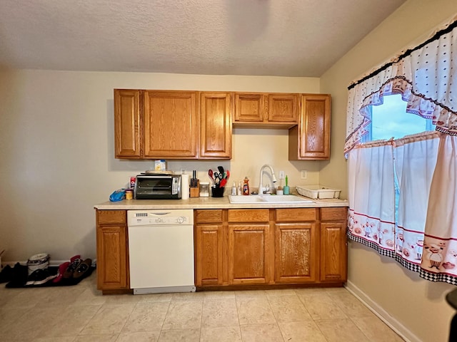 kitchen with light tile patterned flooring, a textured ceiling, white dishwasher, and sink