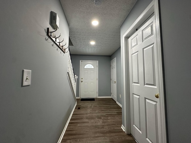 doorway to outside with dark hardwood / wood-style flooring and a textured ceiling