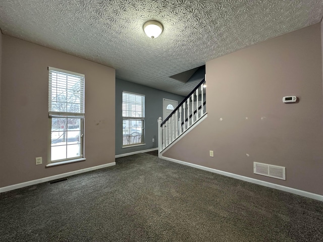 carpeted foyer entrance featuring a textured ceiling