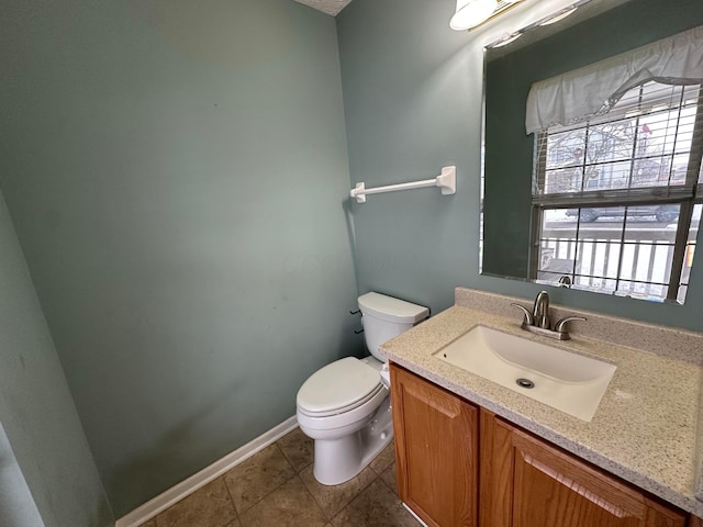 bathroom featuring tile patterned flooring, vanity, and toilet