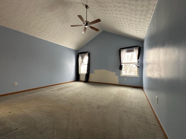 unfurnished room featuring carpet, ceiling fan, a healthy amount of sunlight, and vaulted ceiling