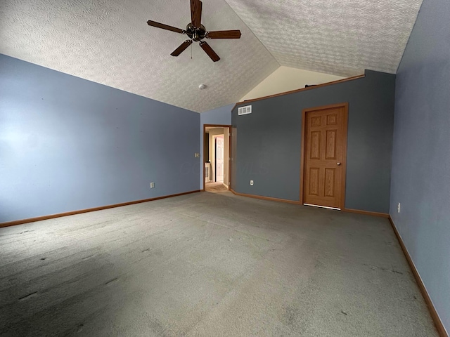 interior space with a textured ceiling, carpet floors, ceiling fan, and lofted ceiling