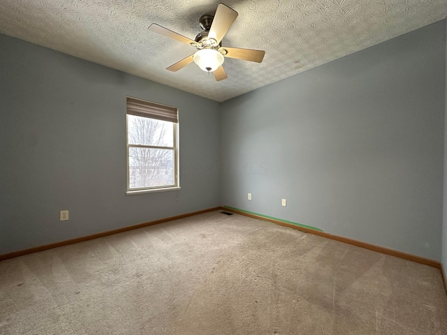 carpeted spare room featuring a textured ceiling and ceiling fan