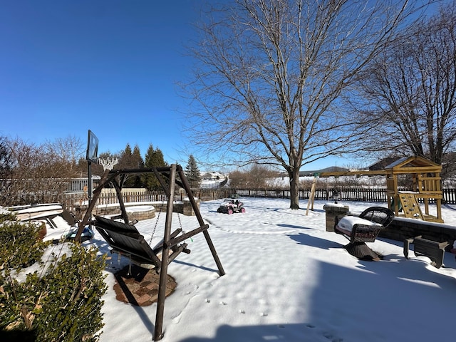 yard layered in snow featuring a playground