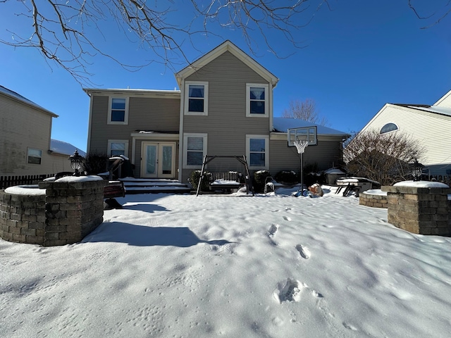 snow covered rear of property featuring french doors